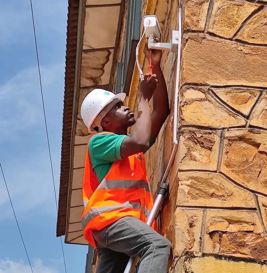 Technicien GKAS-GROUP installant une caméra de surveillance